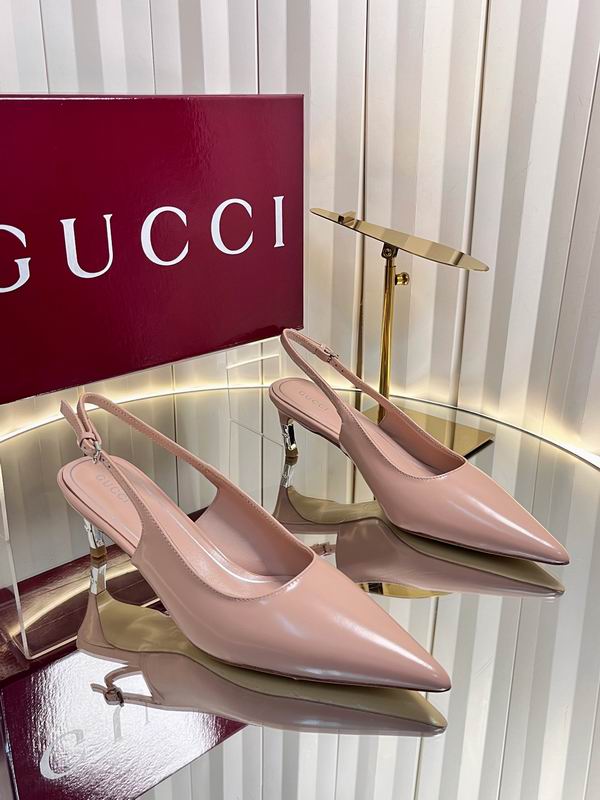 Gucci blush pink leather pointed-toe slingback pumps displayed on glass surface with original red Gucci box